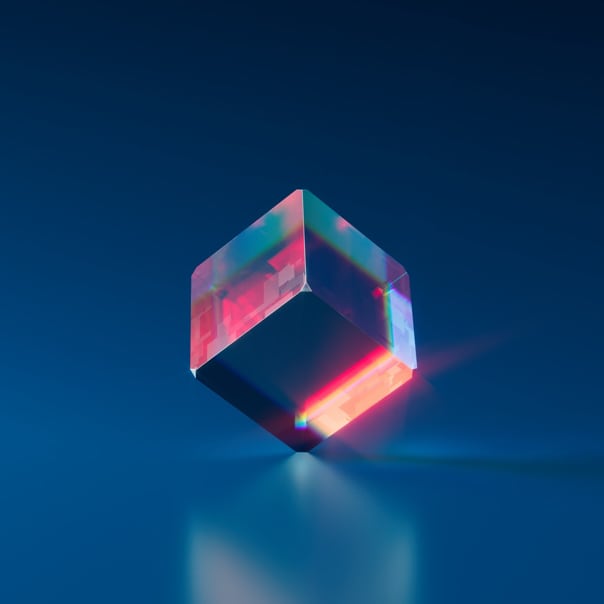 A colorful 3D cube balancing on one of its edges with a Navy blue background